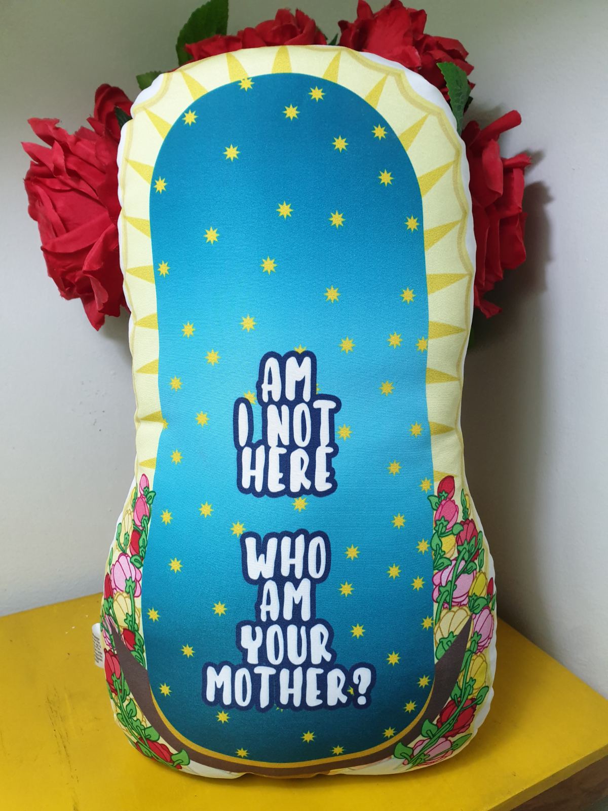 Back of the pillow with a text "Am I not here, who am your mother?"
