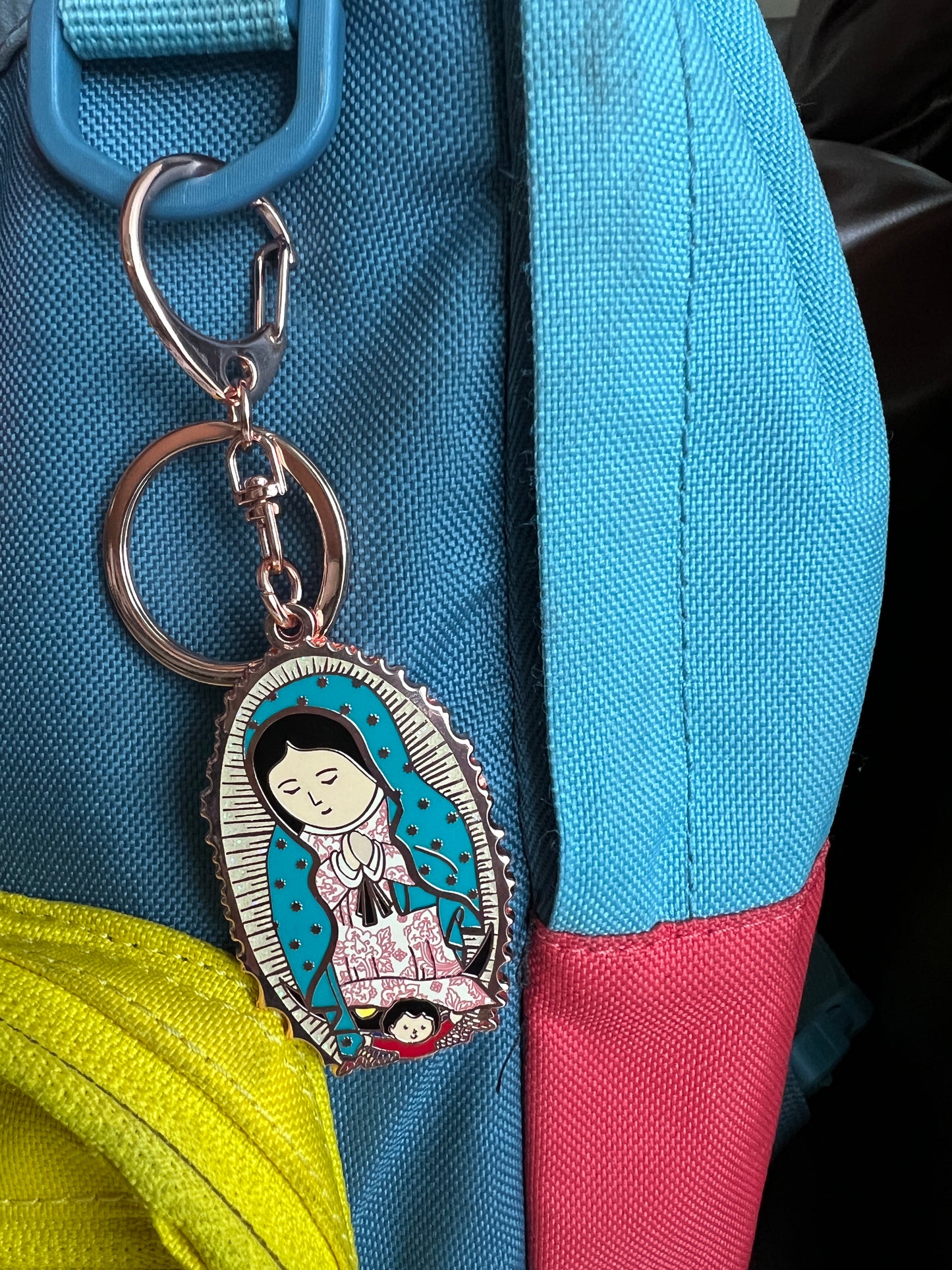 A key chain of Our Lady of Guadalupe attached on the backpack.