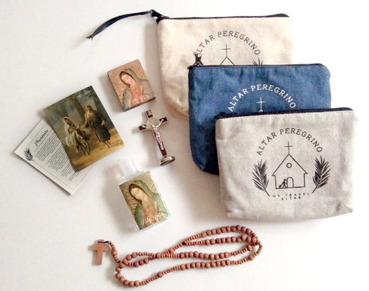 A collection of items including a wooden block with a figure of Our Lady Guadalupe, a crucifix, a rosary, prayer cards, holy water, and a canvas zippered pouch, presumably part of a travel altar set.