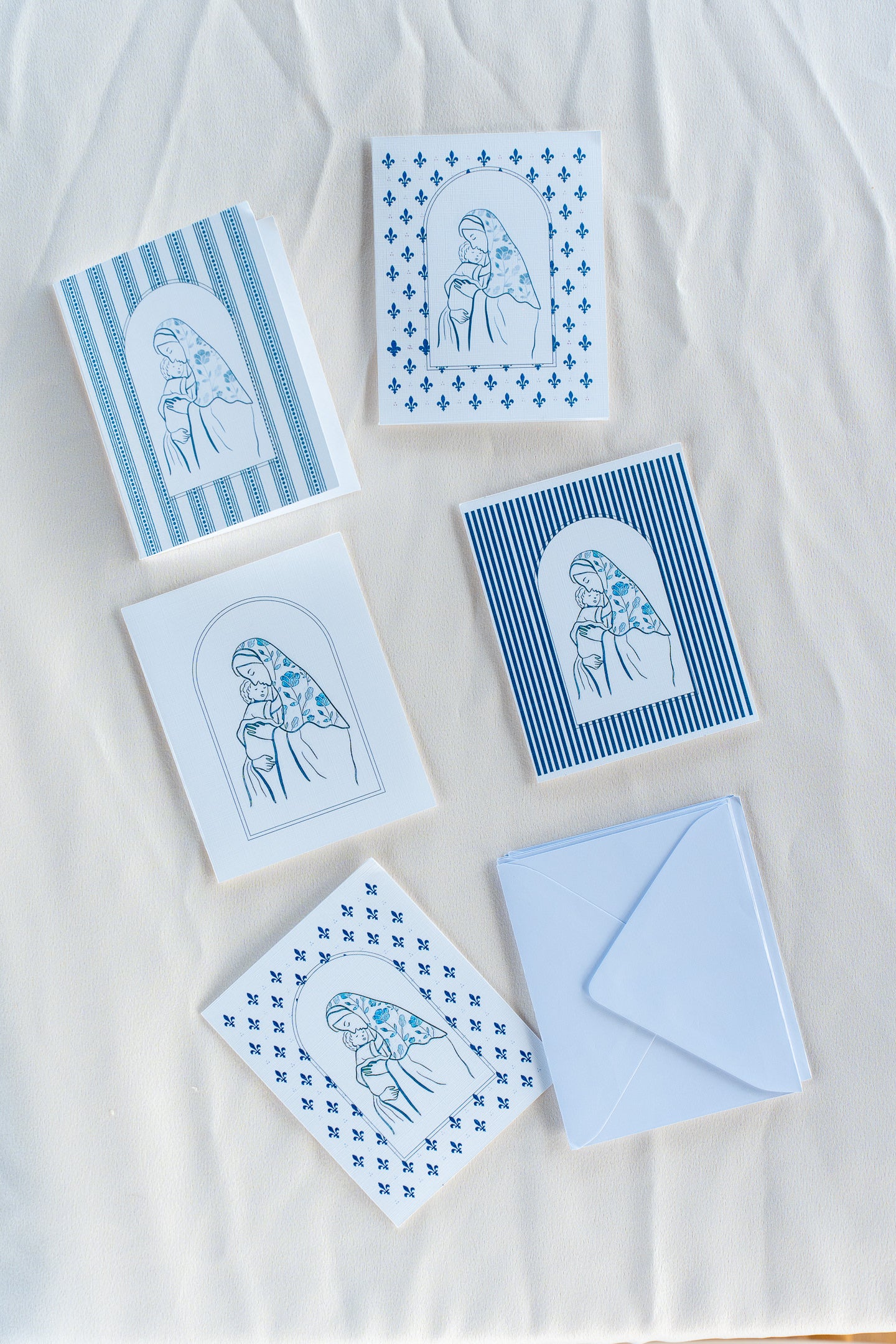 A collection of folded greeting cards with various designs, placed on a white surface.