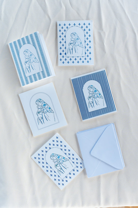 A collection of folded greeting cards with various designs, placed on a white surface.