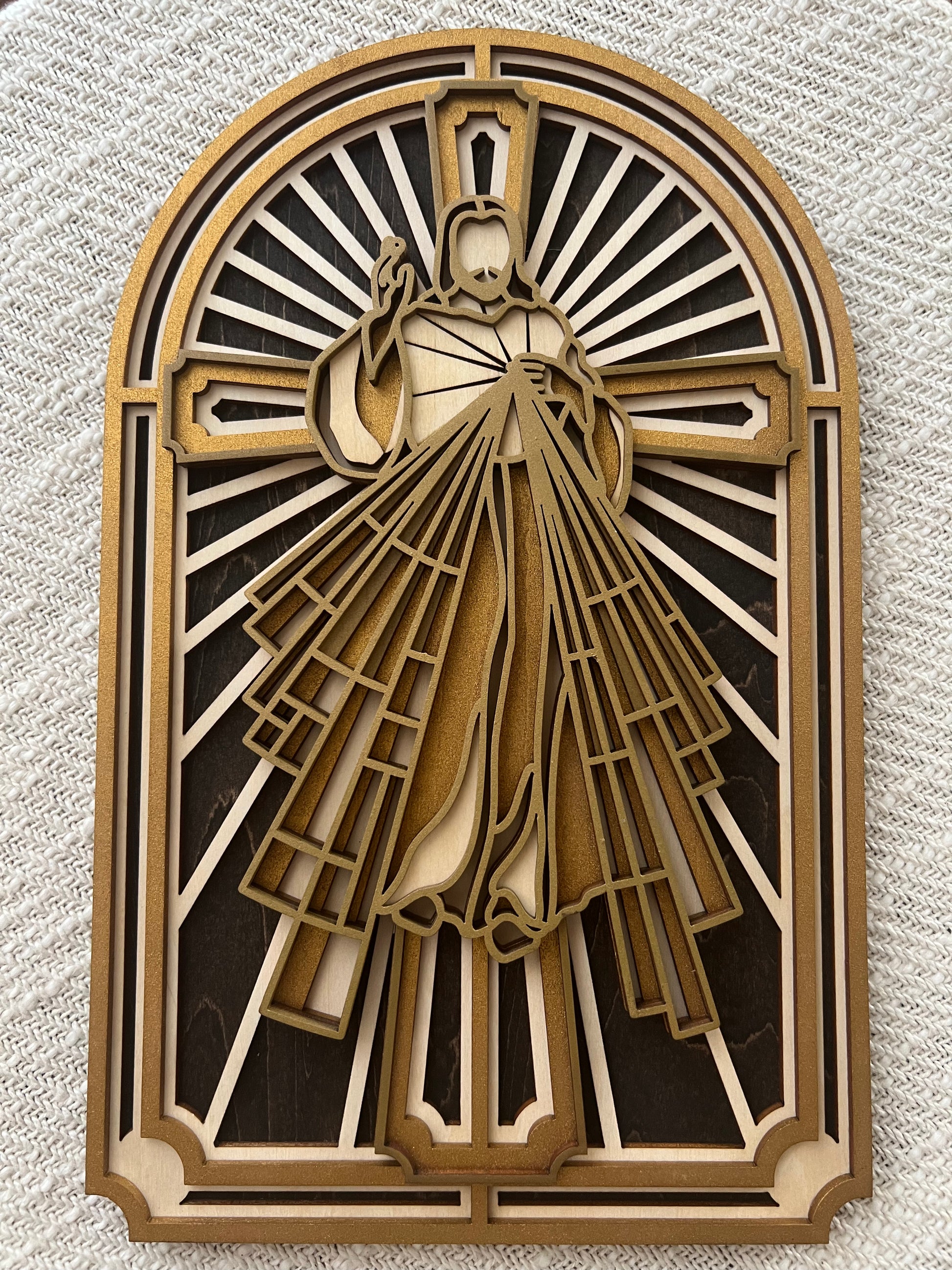A multi-layered wood art depiction of the Sacred Heart of Jesus Christ, with a gold and white color scheme.