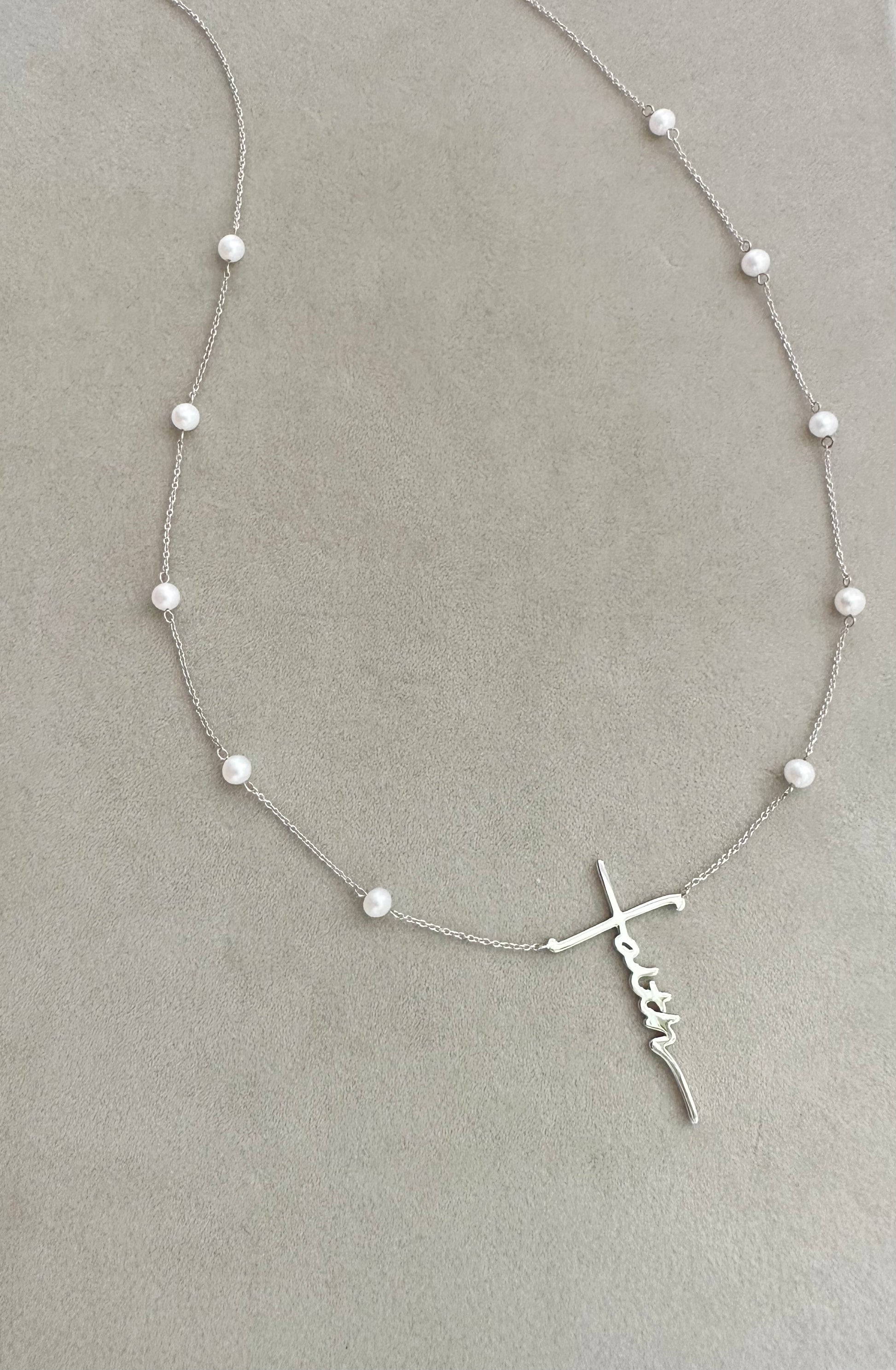 A 14k white gold necklace witch a faith pendant and freshwater pearls. 