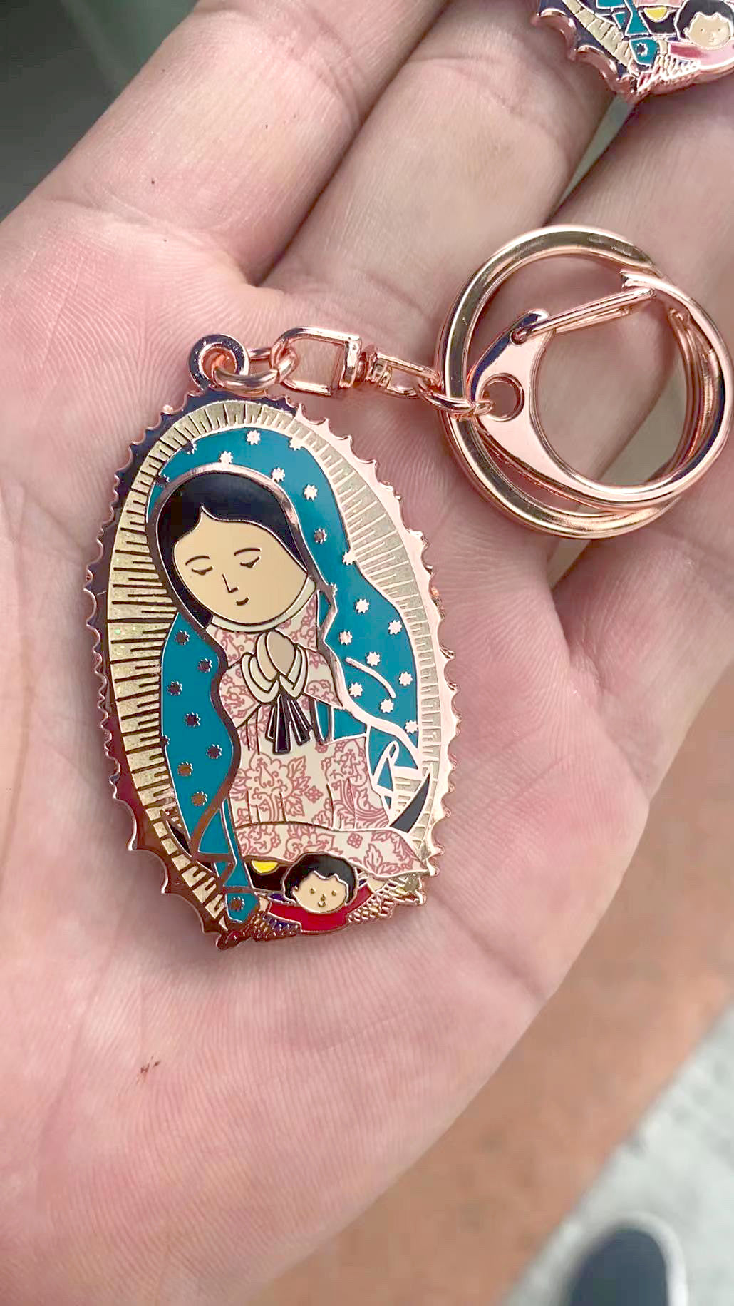 A keychain of Our Lady of Guadalupe placed on a palm of a hand. 