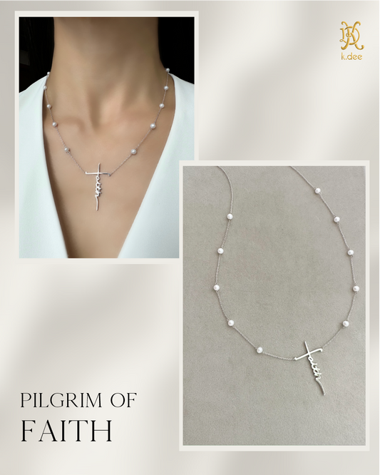 A 14k white gold necklace witch a faith pendant and freshwater pearls, placed on the model. 
